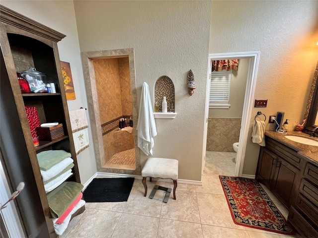 51 S Trillium Ct, Lake Jackson, TX 77566 - full bath with tile patterned floors, vanity, walk in shower, and a textured wall