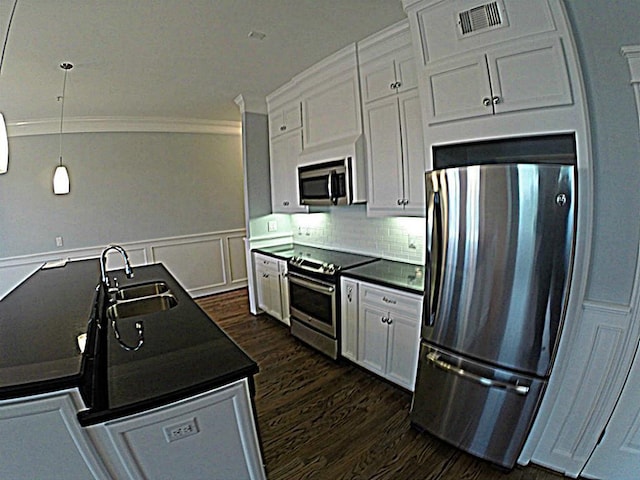 2802 Morrison St Unit 401, Houston, TX 77009 - kitchen with stainless steel appliances, dark countertops, dark wood-type flooring, white cabinets, and crown molding