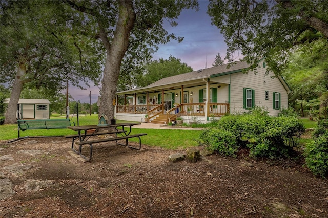 505 Sage Brush Dr, Somerville, TX 77879 - rear view of property with covered porch, a lawn, and an outbuilding