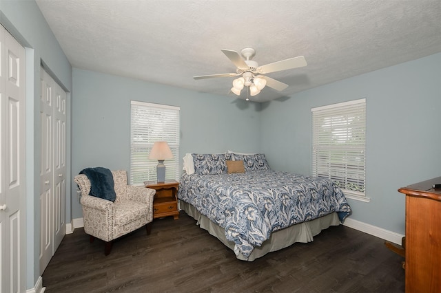 505 Sage Brush Dr, Somerville, TX 77879 - bedroom with dark wood finished floors, multiple windows, a closet, a ceiling fan, and a textured ceiling