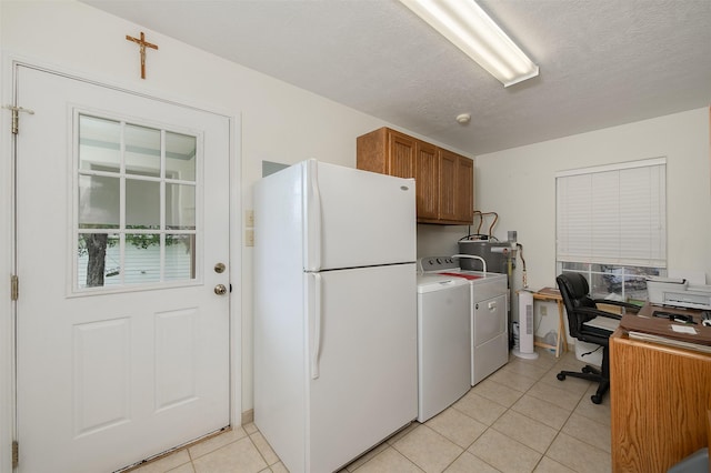 505 Sage Brush Dr, Somerville, TX 77879 - kitchen featuring freestanding refrigerator, brown cabinetry, light tile patterned floors, an office area, and washer and dryer