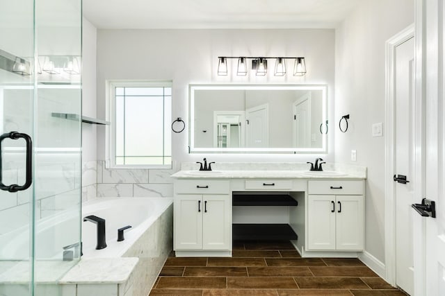 133 Water Grass Trl, Clute, TX 77531 - bathroom featuring double vanity, a bath, and a stall shower