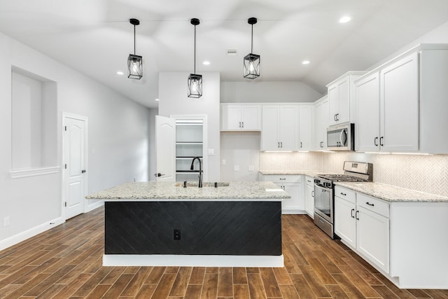 133 Water Grass Trl, Clute, TX 77531 - kitchen with appliances with stainless steel finishes, dark wood-style floors, decorative backsplash, light stone countertops, and white cabinetry
