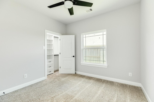 133 Water Grass Trl, Clute, TX 77531 - unfurnished bedroom featuring light carpet, a walk in closet, and ceiling fan