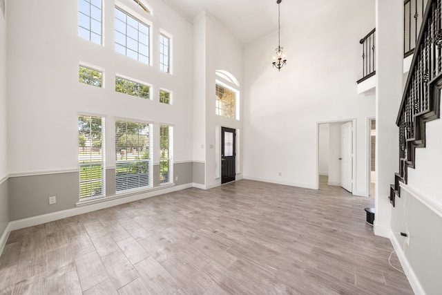 14910 High Meadow Ln, Baytown, TX 77523 - entryway with a towering ceiling, a chandelier, wood finished floors, and stairs
