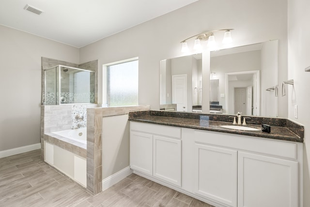 14910 High Meadow Ln, Baytown, TX 77523 - full bathroom featuring a stall shower, a garden tub, double vanity, and wood finish floors