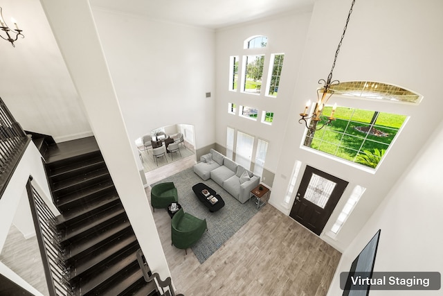 14910 High Meadow Ln, Baytown, TX 77523 - living area with a chandelier, a towering ceiling, wood finished floors, stairway, and ornamental molding