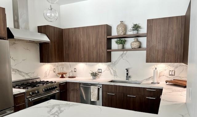 1211 Caroline St Unit 1007, Houston, TX 77002 - kitchen with wall chimney range hood, stainless steel appliances, and modern cabinets