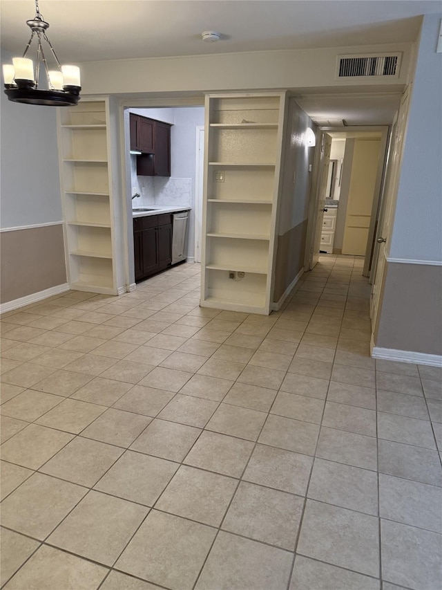 7555 Katy Fwy Unit 57, Houston, TX 77024 - empty room featuring a chandelier, light tile patterned flooring, a smoke detector, and built in shelves