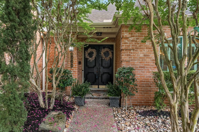 9727 Godstone Ln, Spring, TX 77379 - view of exterior entry with french doors, brick siding, and a shingled roof