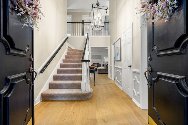 9727 Godstone Ln, Spring, TX 77379 - foyer entrance featuring light wood-style floors, a chandelier, crown molding, stairs, and a high ceiling