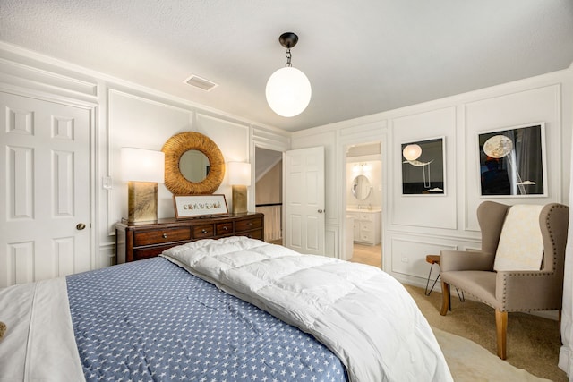 9727 Godstone Ln, Spring, TX 77379 - bedroom featuring a decorative wall, light carpet, and ensuite bath
