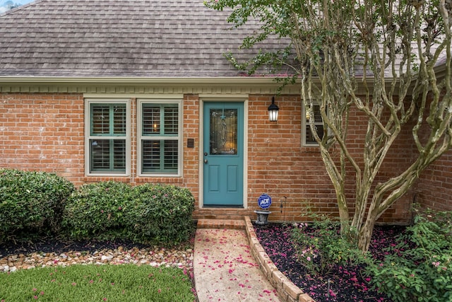 9727 Godstone Ln, Spring, TX 77379 - view of exterior entry with roof with shingles and brick siding