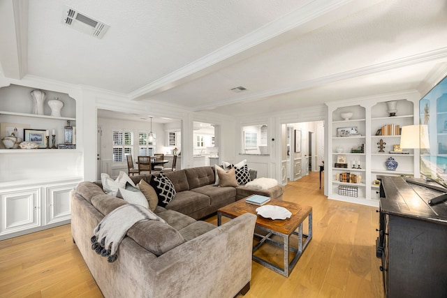 9727 Godstone Ln, Spring, TX 77379 - living room with crown molding, light wood-type flooring, and built in shelves