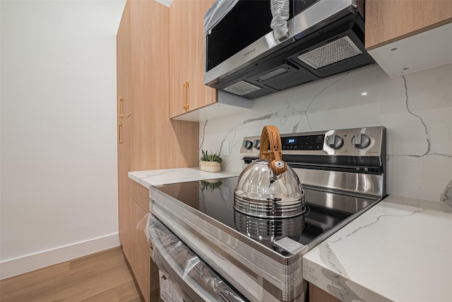 4504 Rosemont St, Houston, TX 77051 - kitchen with stainless steel appliances, light wood-type flooring, light stone counters, and modern cabinets