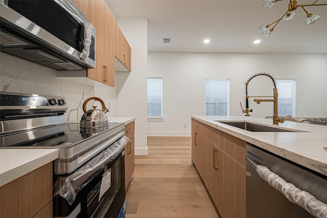 4504 Rosemont St, Houston, TX 77051 - kitchen featuring appliances with stainless steel finishes, modern cabinets, light wood finished floors, recessed lighting, and light stone counters