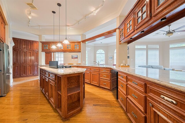 3665 Maranatha Dr, Sugar Land, TX 77479 - kitchen with track lighting, freestanding refrigerator, ceiling fan, brown cabinetry, and dishwasher
