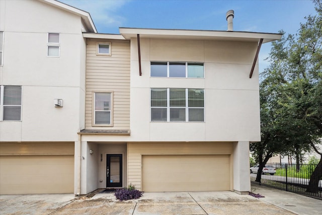 5219 Kiam St Unit F, Houston, TX 77007 - townhome / multi-family property with a garage, concrete driveway, and stucco siding