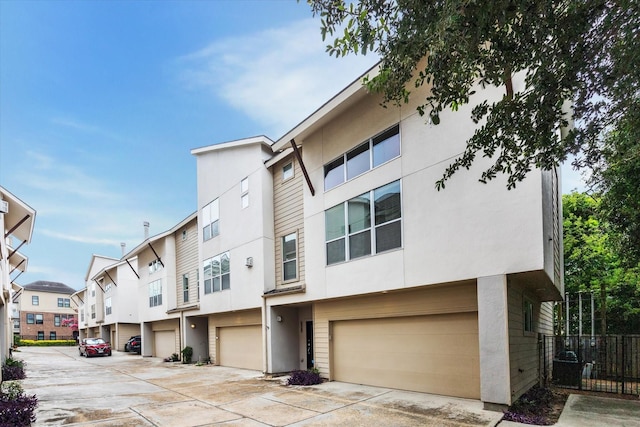 5219 Kiam St Unit F, Houston, TX 77007 - view of front of house with an attached garage, stucco siding, and driveway