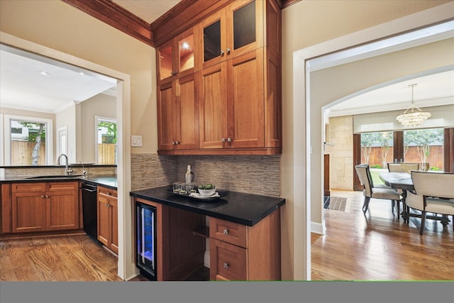 4404 Wendell St, Bellaire, TX 77401 - kitchen with crown molding, black dishwasher, wood finished floors, dark countertops, and a chandelier