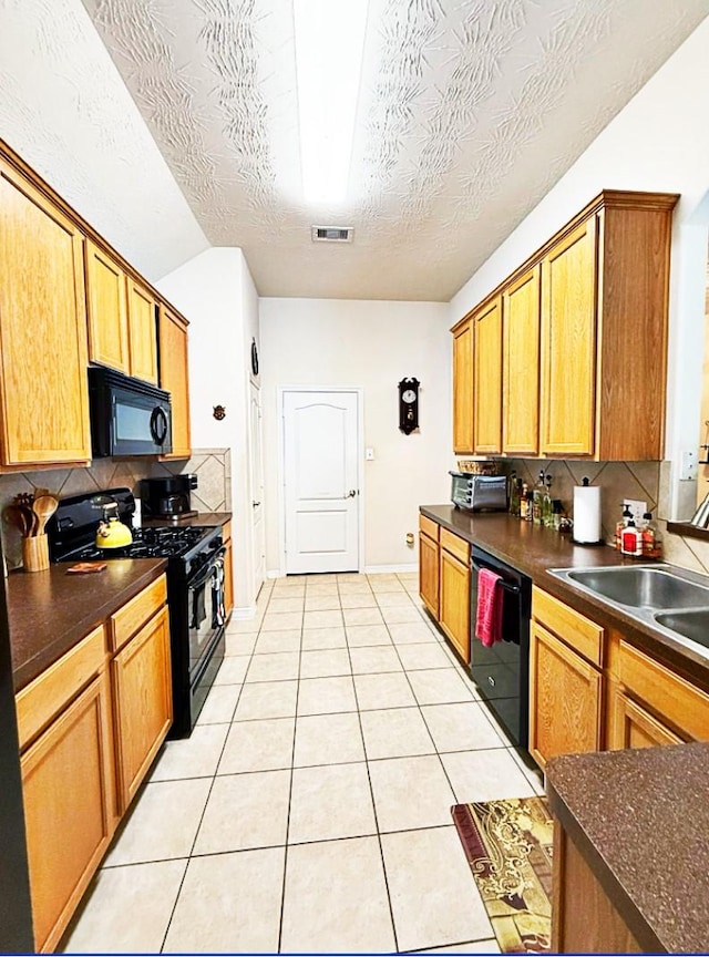 8010 N Tarrytown Crossing Dr, Conroe, TX 77304 - kitchen with black appliances, dark countertops, tasteful backsplash, light tile patterned floors, and a textured ceiling