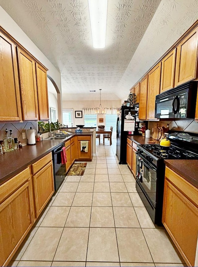 8010 N Tarrytown Crossing Dr, Conroe, TX 77304 - kitchen featuring black appliances, dark countertops, a peninsula, light tile patterned floors, and a textured ceiling