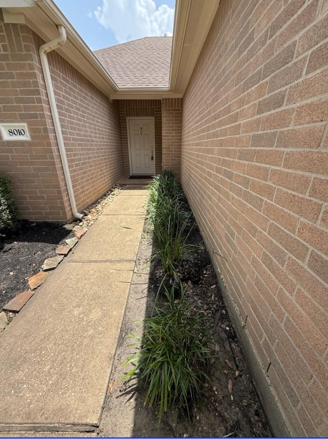 8010 N Tarrytown Crossing Dr, Conroe, TX 77304 - view of exterior entry with roof with shingles and brick siding