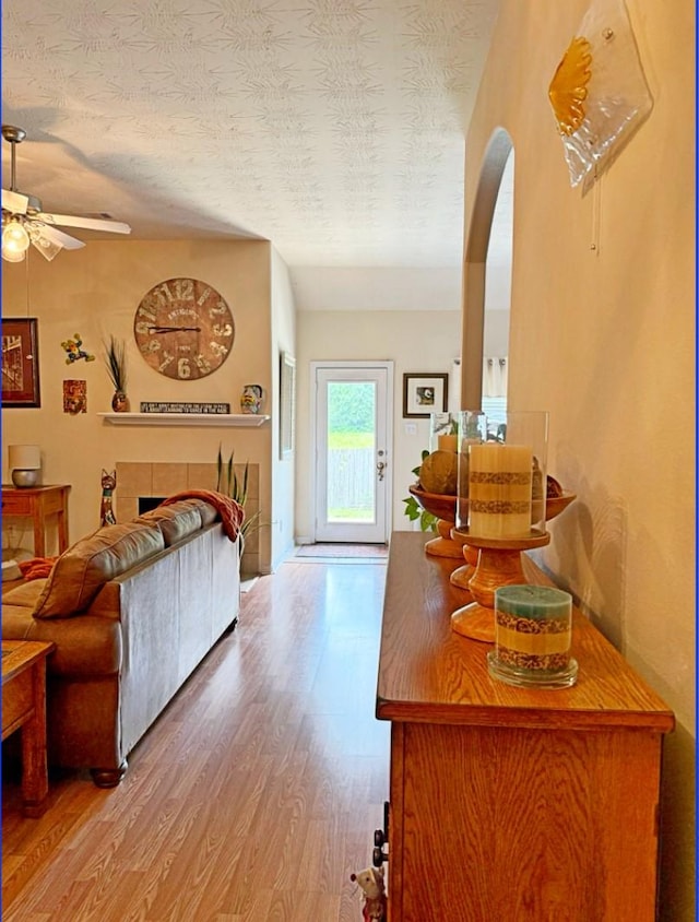 8010 N Tarrytown Crossing Dr, Conroe, TX 77304 - living room featuring wood finished floors, a ceiling fan, arched walkways, and a textured ceiling