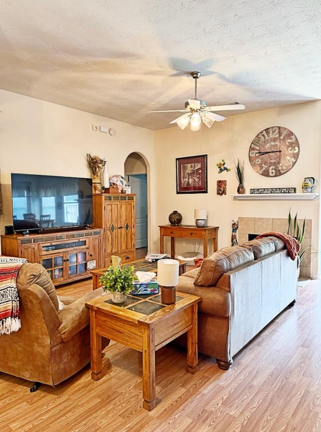 8010 N Tarrytown Crossing Dr, Conroe, TX 77304 - living room with ceiling fan, light wood-type flooring, arched walkways, and a textured ceiling