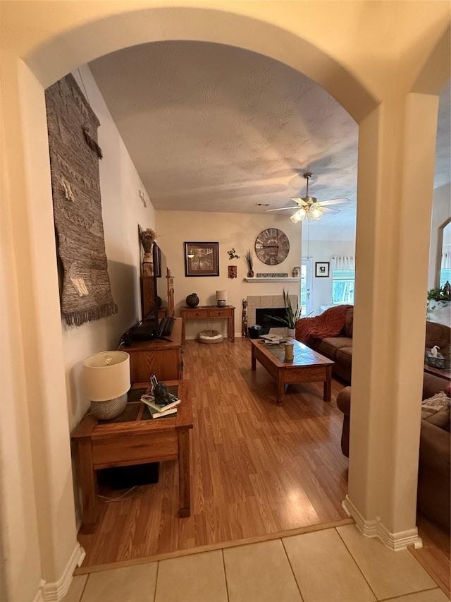 8010 N Tarrytown Crossing Dr, Conroe, TX 77304 - tiled living room with ceiling fan, arched walkways, and a fireplace