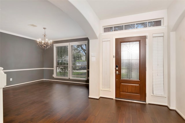 216 Willow Pointe Dr, League City, TX 77573 - foyer entrance featuring a chandelier, dark wood finished floors, arched walkways, and crown molding