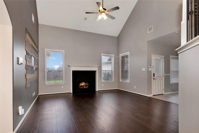 216 Willow Pointe Dr, League City, TX 77573 - unfurnished living room featuring high vaulted ceiling, ceiling fan, a lit fireplace, wood-type flooring, and arched walkways