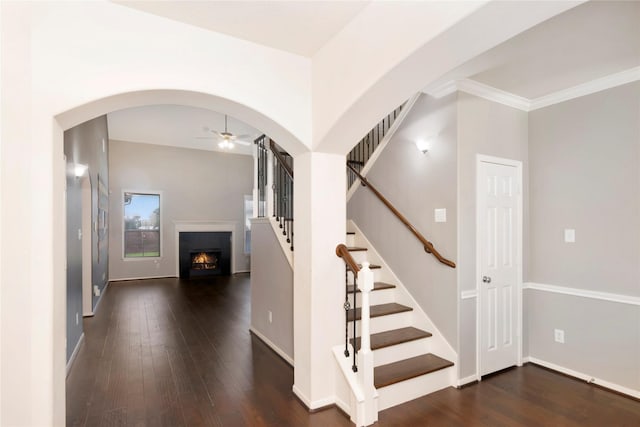 216 Willow Pointe Dr, League City, TX 77573 - stairway featuring ceiling fan, a lit fireplace, arched walkways, hardwood / wood-style floors, and ornamental molding