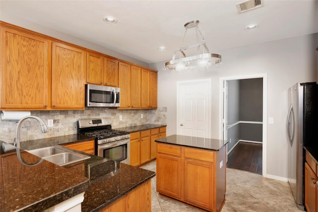 216 Willow Pointe Dr, League City, TX 77573 - kitchen with appliances with stainless steel finishes, backsplash, dark stone counters, a center island, and light tile patterned floors