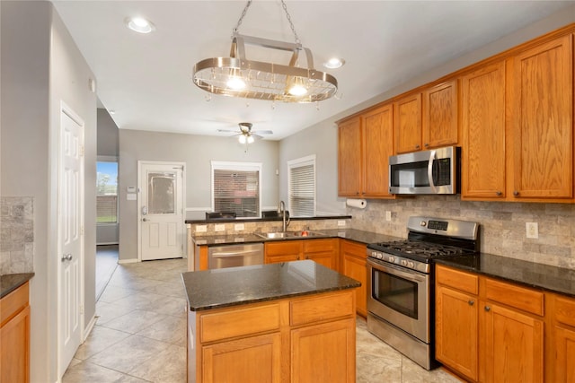 216 Willow Pointe Dr, League City, TX 77573 - kitchen with stainless steel appliances, a peninsula, light tile patterned flooring, a ceiling fan, and decorative backsplash
