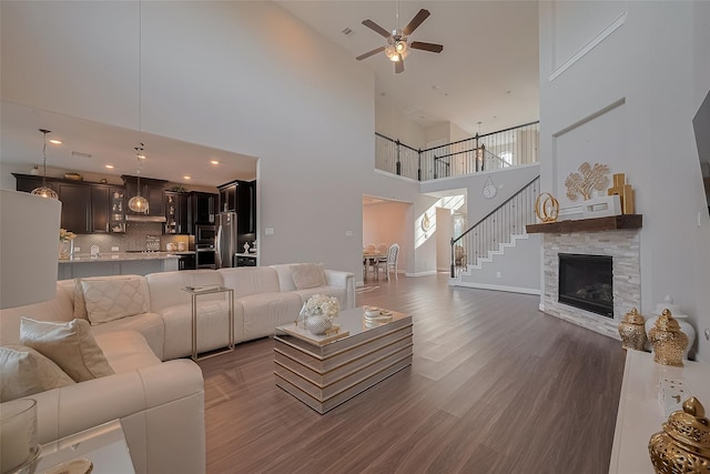 11527 Taagan Ln, Richmond, TX 77407 - living area with high vaulted ceiling, ceiling fan, dark wood finished floors, stairs, and a fireplace
