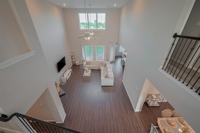11527 Taagan Ln, Richmond, TX 77407 - living room with a high ceiling, a ceiling fan, wood finished floors, and stairs