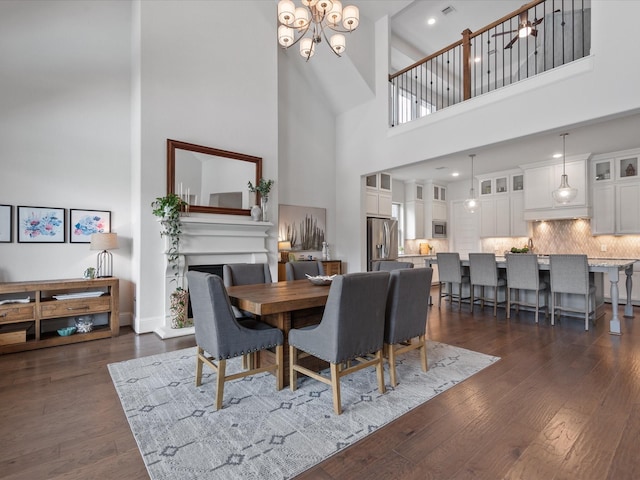 10814 Avery Arbor Ln, Cypress, TX 77433 - dining area with a high ceiling, dark wood finished floors, a fireplace, and a chandelier