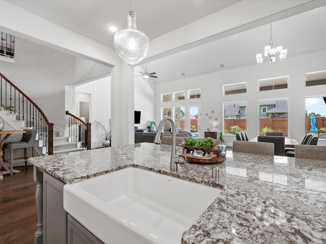 10814 Avery Arbor Ln, Cypress, TX 77433 - kitchen featuring open floor plan, light stone counters, a chandelier, ceiling fan, and pendant lighting