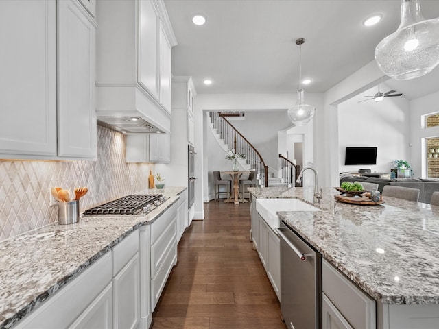 10814 Avery Arbor Ln, Cypress, TX 77433 - kitchen featuring appliances with stainless steel finishes, open floor plan, a ceiling fan, backsplash, and dark wood-style floors