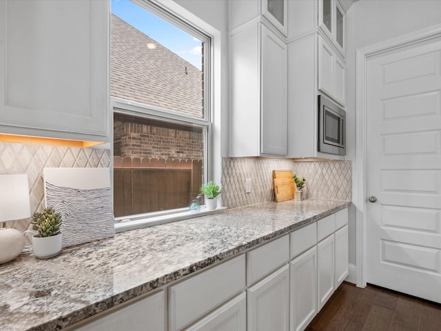 10814 Avery Arbor Ln, Cypress, TX 77433 - kitchen with backsplash, white cabinets, glass insert cabinets, dark wood-style floors, and light stone countertops