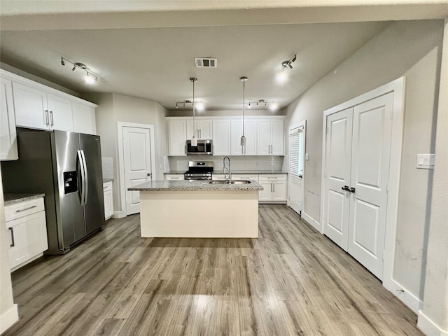 4301 Clover St, Houston, TX 77051 - kitchen featuring appliances with stainless steel finishes, rail lighting, light wood-type flooring, and white cabinetry