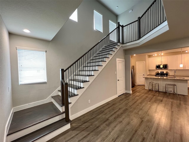 4301 Clover St, Houston, TX 77051 - staircase featuring wood finished floors and a high ceiling