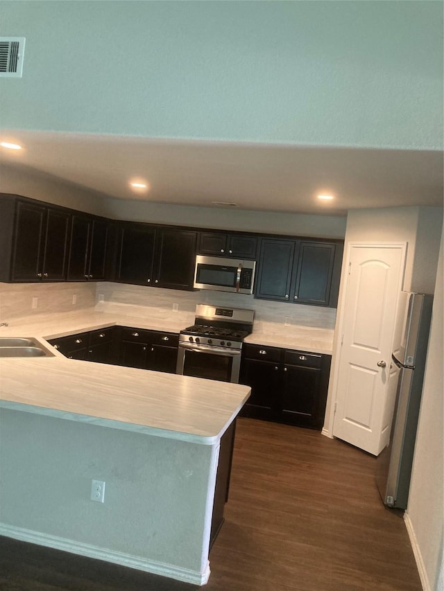 15443 Cipres Verde St, Channelview, TX 77530 - kitchen with stainless steel appliances, light countertops, dark wood-style floors, and a peninsula
