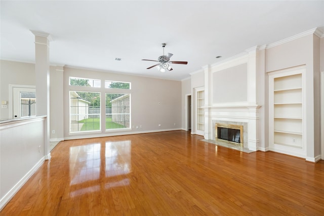 3102 Stargate Ct, Houston, TX 77068 - unfurnished living room with a ceiling fan, wood finished floors, built in features, crown molding, and a premium fireplace