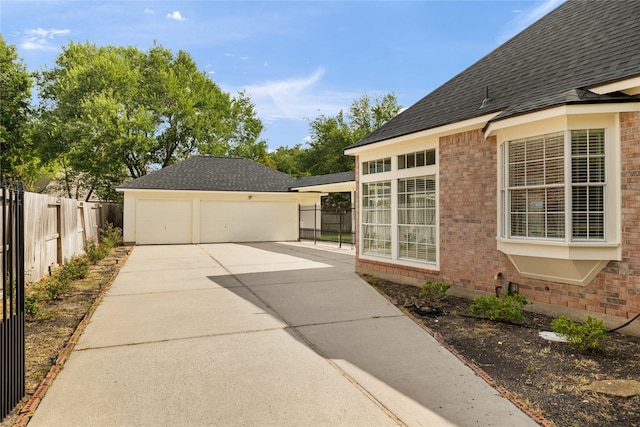 3102 Stargate Ct, Houston, TX 77068 - view of property exterior featuring brick siding, a garage, an outbuilding, and a shingled roof