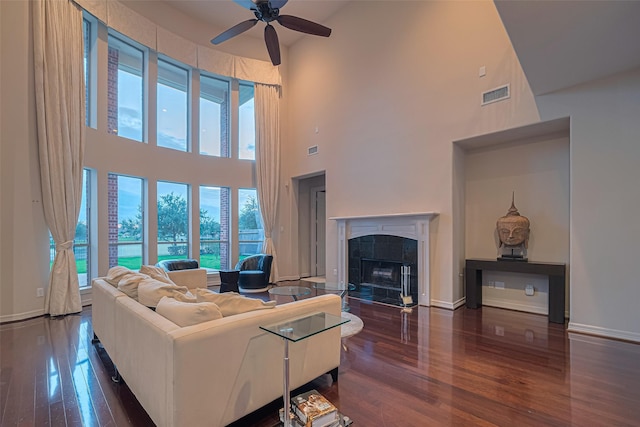 8707 Crossriver Ln, Houston, TX 77095 - living area with ceiling fan, wood-type flooring, a tiled fireplace, and a high ceiling