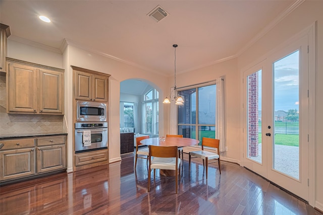 8707 Crossriver Ln, Houston, TX 77095 - kitchen featuring stainless steel appliances, crown molding, dark wood finished floors, arched walkways, and decorative light fixtures