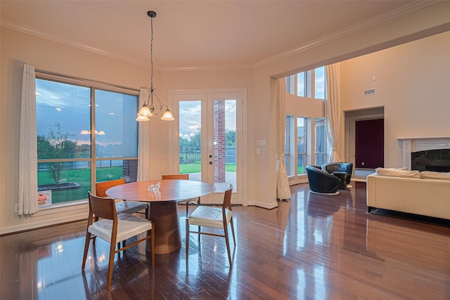 8707 Crossriver Ln, Houston, TX 77095 - dining area featuring wood finished floors, crown molding, a glass covered fireplace, and a chandelier
