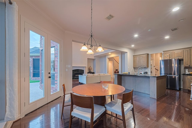 8707 Crossriver Ln, Houston, TX 77095 - dining room with dark wood-type flooring, crown molding, a chandelier, recessed lighting, and french doors